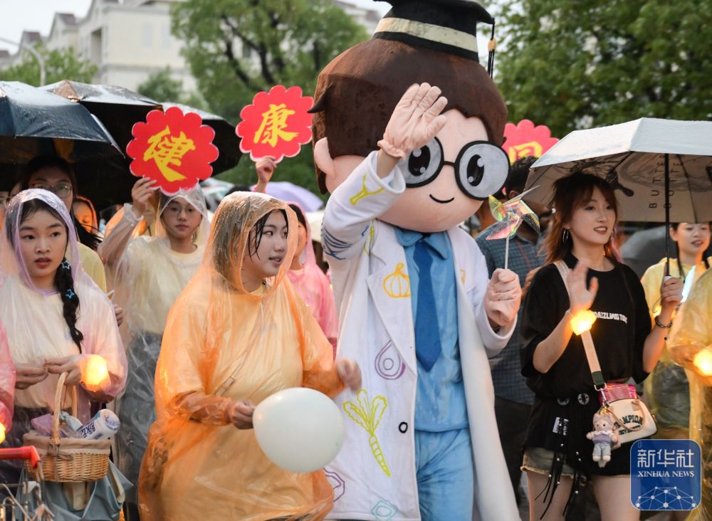 6月21日,beat365正版唯一入口必一学生在校园里冒雨巡游。2